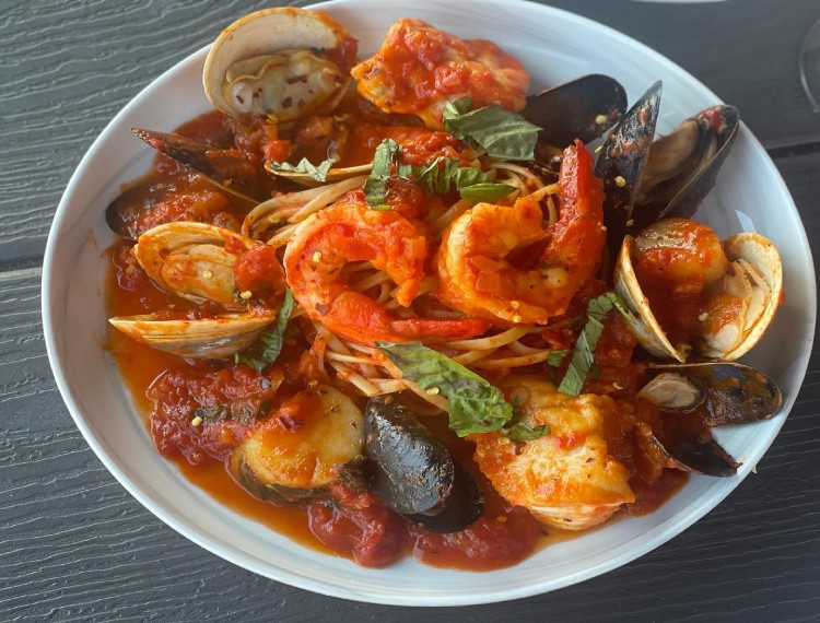 A plate of spaghetti with shrimp and clams on a table.